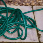 This photo of a garden hose with kinks illustrates the bottlenecks that impede workflow in the business office.