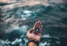 image of man's hand holding compass