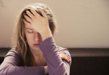 image of overwhelmed girl with her eyes closed and her hand to her forehead